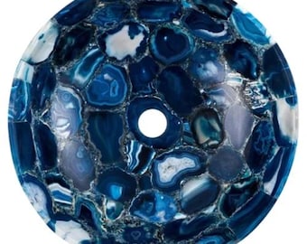 May include: A round, blue agate stone sink with a mosaic pattern. The sink features a variety of blue shades, from deep navy to light sky blue, with white and gray accents. A circular drain hole is visible in the center.