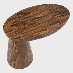 May include: A unique, oval-shaped side table with a mosaic-style top and a flared, pedestal base. The table is constructed from a warm brown material, possibly wood or stone, with a natural, textured appearance. The table has a circular indentation on the top.
