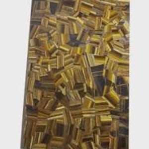 May include: A rectangular slab with a mosaic pattern of golden-brown and black tiger's eye gemstones. The polished surface reflects light, showcasing the natural variations in color and texture of the stones. The overall design is geometric and abstract.
