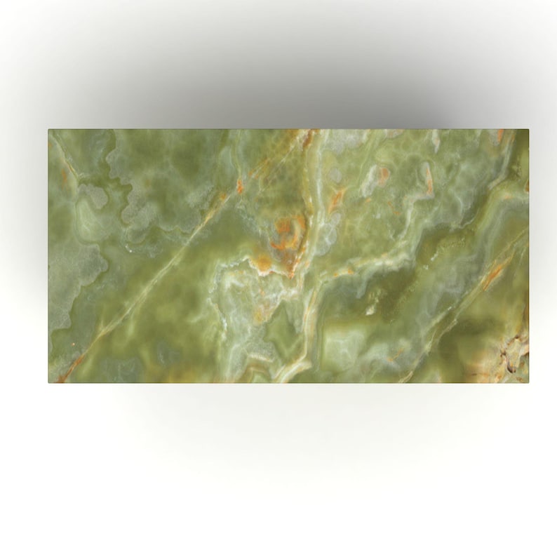 Peut inclure: Une dalle rectangulaire en onyx vert avec un motif naturel et fluide. La pierre pr&eacute;sente des nuances de vert, avec des veines dor&eacute;es et brunes. La surface a un aspect poli, refl&eacute;tant la lumi&egrave;re et mettant en valeur le veinage unique de la pierre.