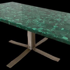 Puede incluir: Mesa rectangular con tapa verde malaquita y base de acero inoxidable en forma de estrella. La tapa de la mesa tiene un acabado brillante y un patrón único de tonos verdes oscuros y claros. Diseño moderno.