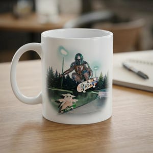 May include: White ceramic mug featuring a colorful illustration of a character in Mandalorian armor skateboarding. The design includes a green-skinned character on a skateboard, set against a park scene with trees and lights.
