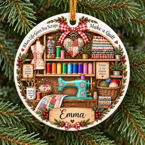 May include: A round ceramic ornament featuring a sewing room scene with a teal sewing machine, fabric stacks, spools of thread, a mannequin, and a quilt. The text reads When Life Gives You Scraps Make a Quilt, Fabric is my Happy Place, and Emma.
