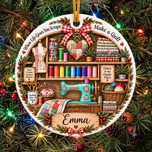 May include: A round ceramic ornament featuring a sewing room scene with a teal sewing machine, colorful thread spools, fabric stacks, and a mannequin. Text reads: When Life Gives You Scraps Make a Quilt, Sew Create Inspire Repeat, Fabric is my Happy Place, and Emma.