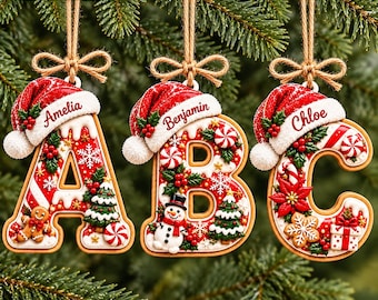 May include: Three hanging Christmas ornaments shaped like the letters A, B, and C. Each letter features a red Santa hat, white icing, and festive decorations like gingerbread men, snowmen, poinsettias, and candy canes with names Amelia, Benjamin, and Chloe.