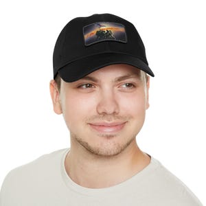 May include: Black baseball cap with a rectangular patch featuring a patriotic image of soldiers raising a flag against a sunset backdrop. The cap is made of a durable fabric and has a curved brim.
