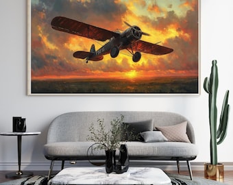 May include: A framed art print of a vintage airplane soaring through a fiery sunset. The biplane is dark with red wings, set against a vibrant sky of orange, yellow, and red hues. The artwork is displayed above a gray sofa.