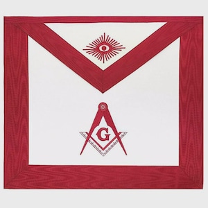 May include: A white Masonic apron with a red border and accents. The apron features a red eye design at the top and a compass and square emblem with the letter "G" in the center. The apron is rectangular with a triangular top.