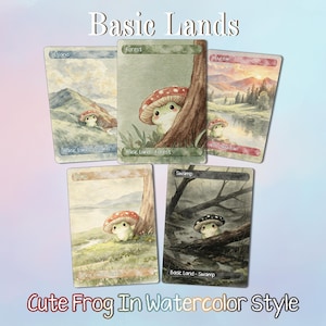 May include: Five rectangular trading cards titled Basic Lands featuring watercolor illustrations of frogs with mushroom caps. The cards are labeled Island, Forest, Mountain, Plains, and Swamp, each depicting a frog in a different landscape setting.