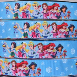 May include: Blue ribbon with a repeating pattern of Disney princesses dressed in winter outfits and holding ornaments. The princesses include Snow White, Cinderella, Belle, Ariel, Jasmine, and more.