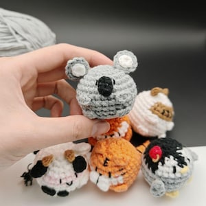 Puede incluir: Colección de figuras de animales de ganchillo hechas a mano, que incluyen un koala gris, un zorro naranja y un pingüino blanco y negro. Las figuras son pequeñas, redondas y elaboradas con hilo, mostrando detalles.