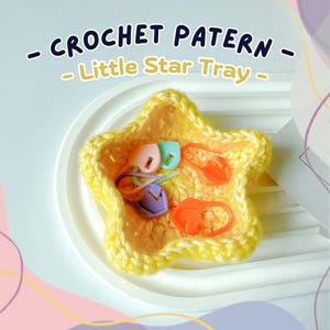 May include: A yellow crocheted star-shaped tray with colorful stitch markers. The tray is filled with various colored stitch markers, including orange, purple, and teal. The text "CROCHET PATTERN - Little Star Tray -" is displayed at the top.