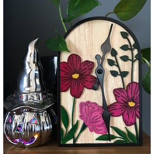 Peut inclure: Une tasse en céramique blanche avec une anse noire et l'inscription "But First, Coffee" en gras noir. La tasse est posée sur un fond flou, suggérant un cadre chaleureux.