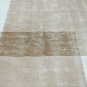 Pu&ograve; includere: Un tappeto moderno con un design geometrico. Il tappeto presenta una combinazione di sezioni beige e bianco sporco, creando un effetto a strati. La sezione centrale &egrave; di una tonalit&agrave; beige pi&ugrave; scura.