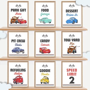 May include: Nine framed signs with cartoon car graphics and text. Signs include "Park Gift Here," "Food Garage," "Dessert Drive-In," "Pit Crew Tools," "Candy Corner," "Tow Yard Fun," "Refueling Station," "Goodie Treats," and "Speed Limit 2."