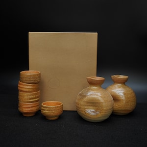 May include: A white ceramic mug with a black handle and the text "But First, Coffee" in a bold, black font. The mug is set against a plain white background, highlighting its simple design.