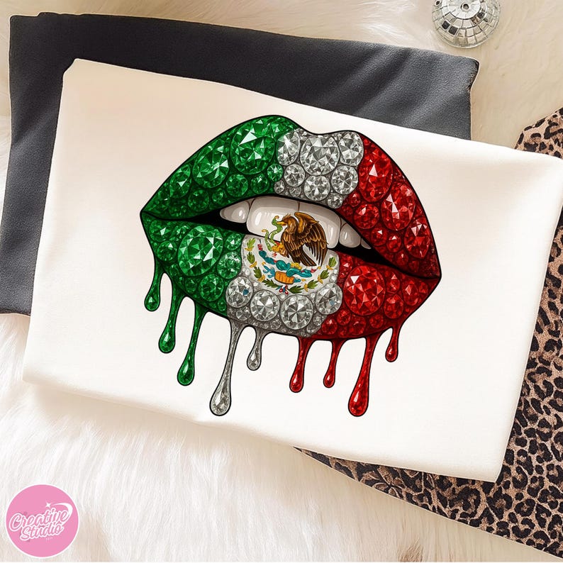 May include: White t-shirt featuring a graphic of stylized lips in the colors of the Mexican flag: green, white, and red. The lips are embellished with gems and dripping with a metallic silver and red liquid.