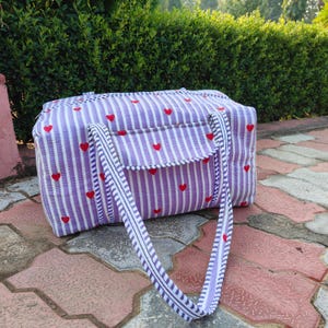 Puede incluir: Una taza de cerámica blanca con un asa negra y el texto "But First, Coffee" en negro, con una fuente de estilo manuscrito. La taza está sobre una superficie blanca.