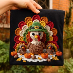 May include: Black square featuring a crochet Thanksgiving turkey design. The turkey has a brown body, white chest, and a green pilgrim hat. Two smaller turkeys, pumpkins, and fall leaves are also included in the design.