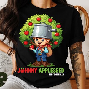 May include: Black t-shirt featuring a cartoon illustration of Johnny Appleseed. The design shows a boy with a pot on his head, standing near an apple tree. The text "JOHNNY APPLESEED SEPTEMBER 26" is printed below the image.