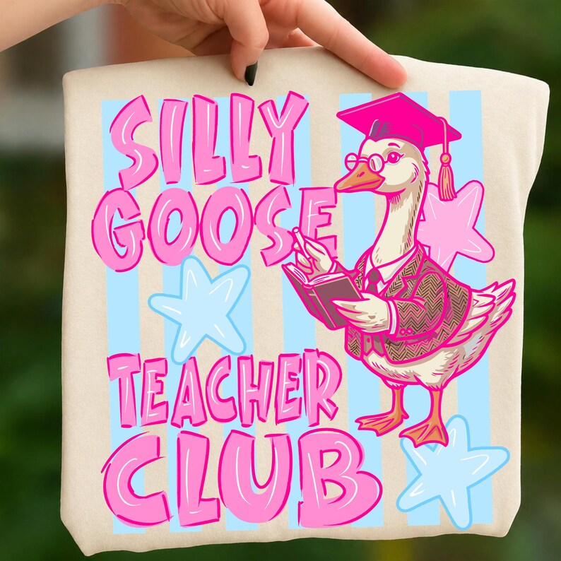 Puede incluir: Un bolso tote beige con la frase "SILLY GOOSE TEACHER CLUB" en rosa. Un ganso de dibujos animados con birrete, gafas y blazer sostiene un libro. Estrellas y rayas azules claras y rosas en el fondo.