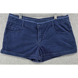 May include: A white ceramic mug with a black handle and the text "But First, Coffee" in a black, handwritten-style font. The mug is on a white surface.