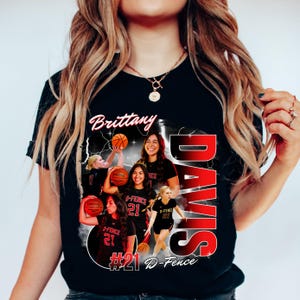 May include: Black t-shirt featuring a basketball design with the name "Brittany" and the name "Davis" in red. The shirt includes images of basketball players and the text "#21 D-Fence".