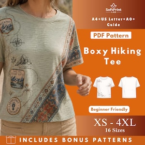May include: A light green t-shirt featuring a map design with the text "Wild & Free" and "Take the Scenic Route". The shirt has a decorative border with a blue and orange pattern. The image also includes the text "Boxy Hiking Tee" and "XS - 4XL".