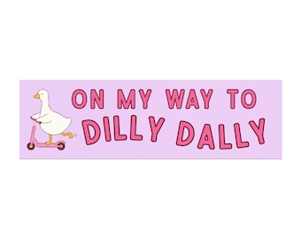 May include: A rectangular sticker with a light purple background. A white cartoon duck rides a pink scooter to the left. The text "ON MY WAY TO DILLY DALLY" is in pink, outlined in a darker pink.