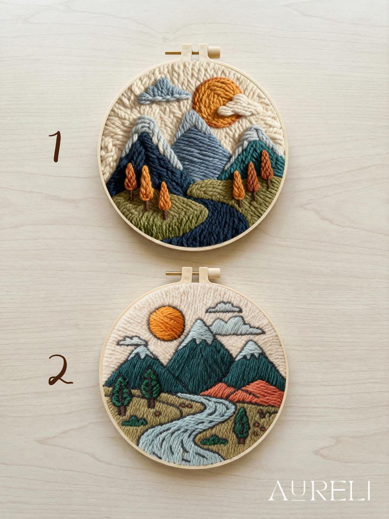 May include: Two round embroidery hoops with landscape scenes. One features mountains, a river, trees, and a sun. The other has a similar design with a river, mountains, trees, and a sun. The embroidery is done with various shades of blue, green, orange, and beige.