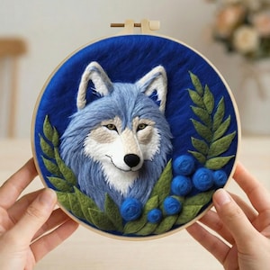 May include: Embroidered artwork in a wooden hoop, depicting a blue wolf with white details, green leaves, and blue berries. The background is a deep blue. The number 1 is visible in the top left corner.