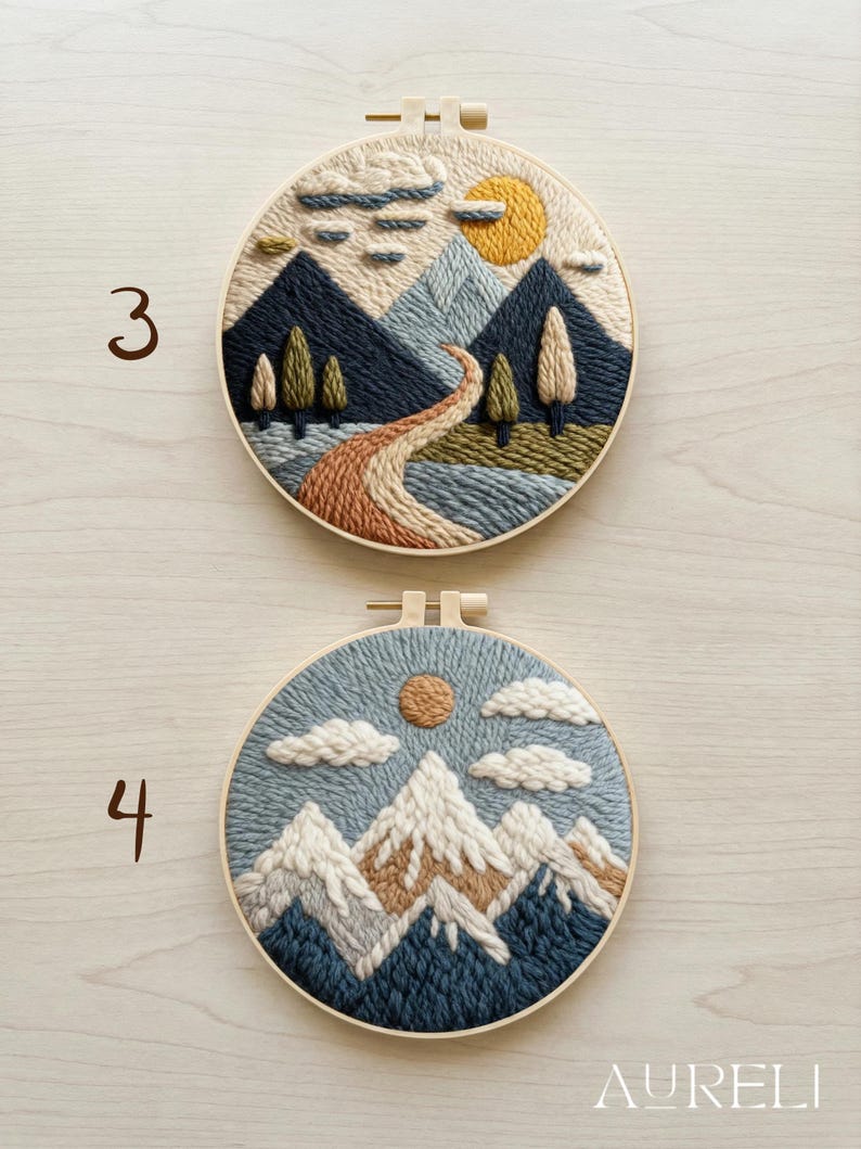 May include: Two embroidered landscape art pieces in wooden hoops. One features a mountain scene with a river, trees, and a sun. The other depicts snow-capped mountains, clouds, and a sun. The word "AURELI" is at the bottom.