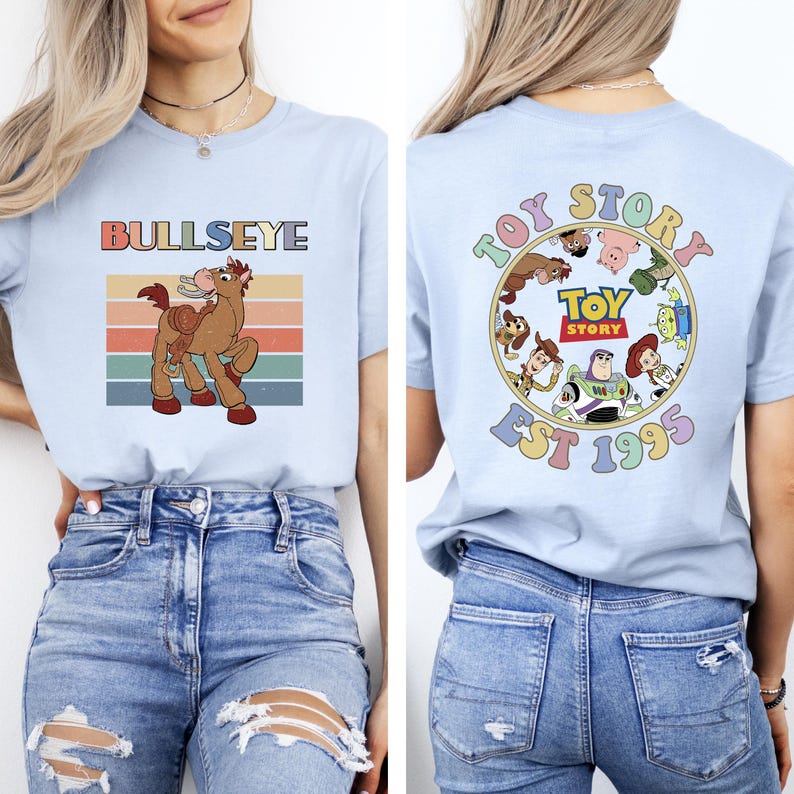 Może przedstawiać: Jasnoniebieska koszulka z grafiką Bullseye i napisem "BULLSEYE". Tył przedstawia okrągły wz&oacute;r z "TOY STORY" i "EST 1995" z postaciami z Toy Story. Casualowy top z kr&oacute;tkim rękawem.