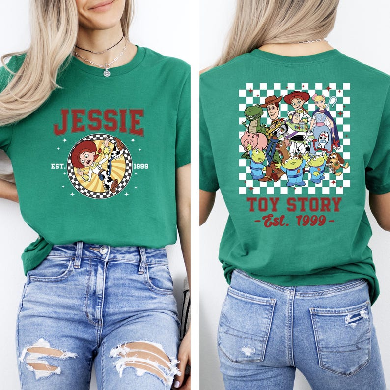 Puede incluir: Camiseta verde con Jessie de Toy Story en la parte delantera, con el texto "JESSIE" y "EST. 1999". La parte trasera muestra un grupo de personajes de Toy Story sobre un fondo a cuadros con el texto "TOY STORY - Est. 1999 -".