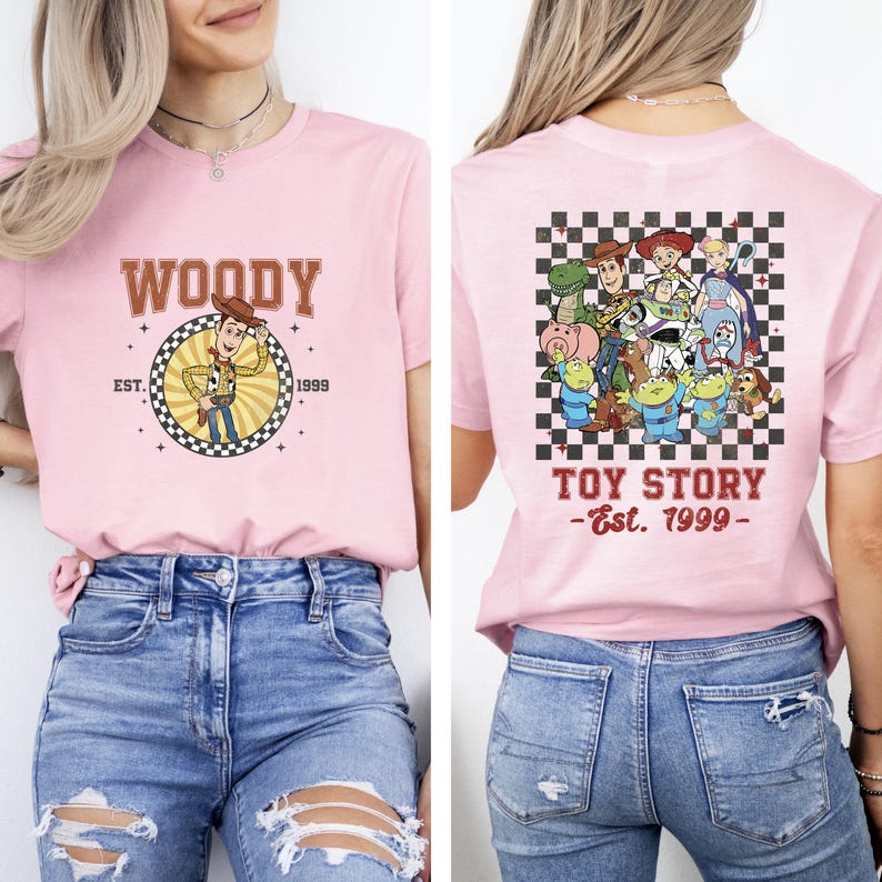 K&ouml;nnte beinhalten: Hellrosa T-Shirt mit Woody aus Toy Story. Auf der Vorderseite steht Woodys Name und "Est. 1999" in einem Kreis. Auf der R&uuml;ckseite sind Toy Story-Charaktere auf kariertem Hintergrund mit dem Text "Toy Story - Est. 1999" abgebildet.
