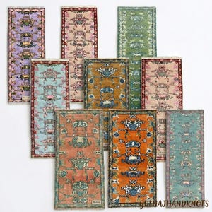 May include: A collection of small, rectangular rugs in various colors, including purple, pink, green, and orange. Each rug features an intricate floral pattern with a central medallion design and fringed edges. The rugs are displayed on a white background.