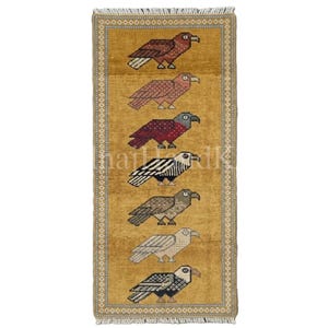 Puede incluir: Una alfombra rectangular con fondo amarillo mostaza que presenta siete aves estilizadas dispuestas en una columna vertical. Cada ave está representada en un color diferente, incluyendo tonos marrones, rojos, negros, blancos y grises, con un borde.