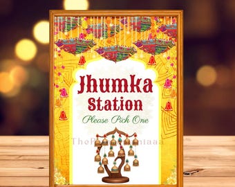 Könnte beinhalten: Ein gerahmtes Schild mit dem Text "Jhumka Station" und "Please Pick One". Das Schild hat einen goldenen Rahmen und einen gelben Hintergrund mit dekorativen Elementen. Oben auf dem Schild steht "Jhumka/Earring Station Signs".