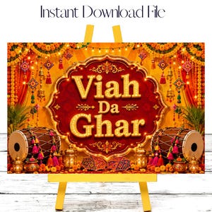 May include: A digital sign featuring the text Viah Da Ghar in gold lettering on a dark red ornate background. The scene is decorated with yellow marigold garlands, hanging lanterns, and two dhol drums on either side of the central frame.