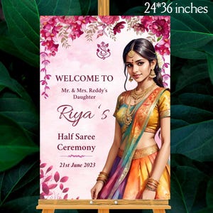 May include: A sign that is 24 x 36 inches, with the text "WELCOME TO Mr. & Mrs. Reddy's Daughter Riya's Half Saree Ceremony 21st June 2023". The sign has a pink background with floral accents and an illustration of a woman in a saree.
