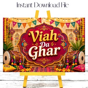 May include: A digital sign featuring the text Viah Da Ghar in a central maroon ornate frame. The design includes colourful bunting, string lights, two dhol drums, marigold flowers, and decorative pots on a patterned background for event decor.