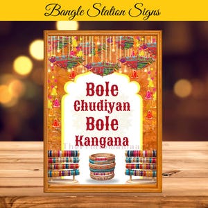 May include: A framed sign featuring the text "Bole Chudiyan Bole Kangana" in a decorative font. The sign is decorated with colourful bangles and festive decorations, suggesting a cultural event or celebration. The words "Bangle Station Signs" are at the top.