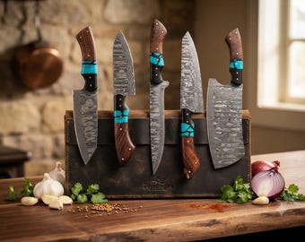 May include: A set of five Damascus steel knives with patterned blades and wooden handles featuring turquoise resin inlays. The knives are displayed in a brown leather roll with the word Handcrafted embossed on the front surface.