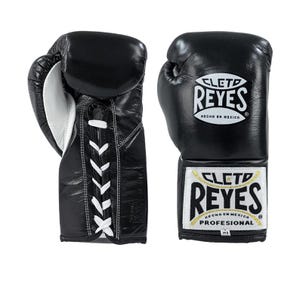 Puede incluir: Par de guantes de boxeo de cuero negro con cordones y detalles blancos. Los guantes presentan el logotipo "CLETO REYES" en blanco y dorado. "HECHO EN MEXICO" está impreso en los guantes.