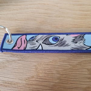 double sided keychain\ keyring with embroidered anime designs. Great gift for demon hunting anime fans