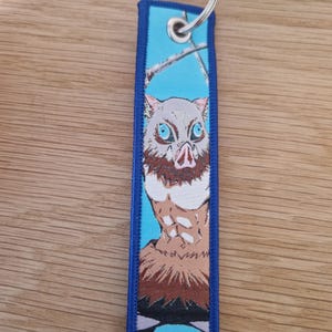 double sided keychain\ keyring with embroidered anime designs. Great gift for demon hunting anime fans