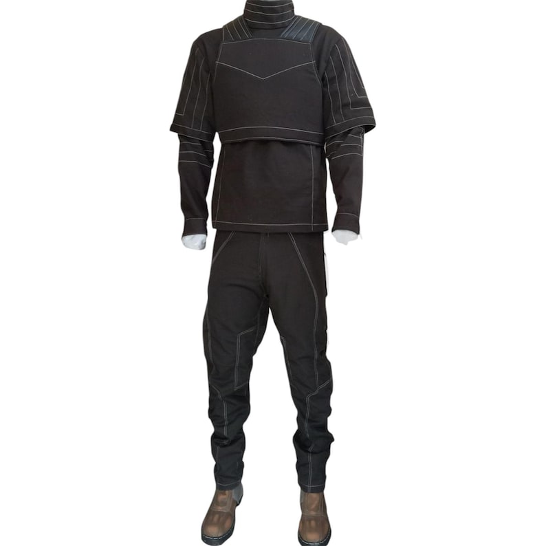 May include: A black outfit consisting of a long-sleeved top, a cropped vest, and pants. The outfit features white stitching details and is paired with brown boots. The top has a high collar, and the vest has a unique design.