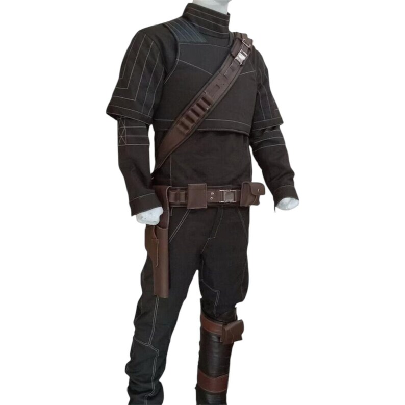 May include: A black costume with a high collar, shoulder pads, and a brown leather belt with a holster. The costume includes a matching brown leather strap across the chest and a brown leather holster on the leg. White stitching accents the costume.