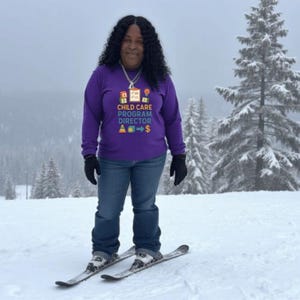 以下が含まれることがあります： 「CHILD CARE PROGRAM DIRECTOR」の文字が白と黄色でプリントされた紫色の長袖シャツを着た人。青いジーンズ、黒い手袋、雪山でスキーをしています。