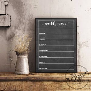 May include: A black chalkboard with a white frame and the text "weekly menu" written in cursive. The chalkboard is divided into seven sections, one for each day of the week, with the days of the week listed in white text.
